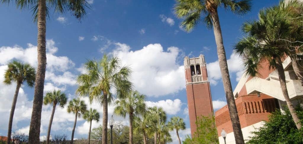 palm trees and a large brick campus building