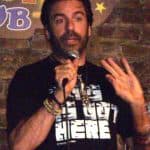 Greg Giraldo, a highly educated comedian, doing standup.