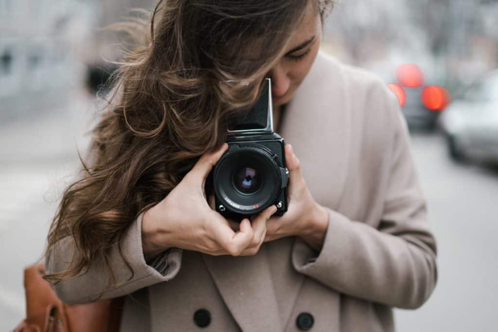 young woman taking photos with old fashioned camera on 4413743